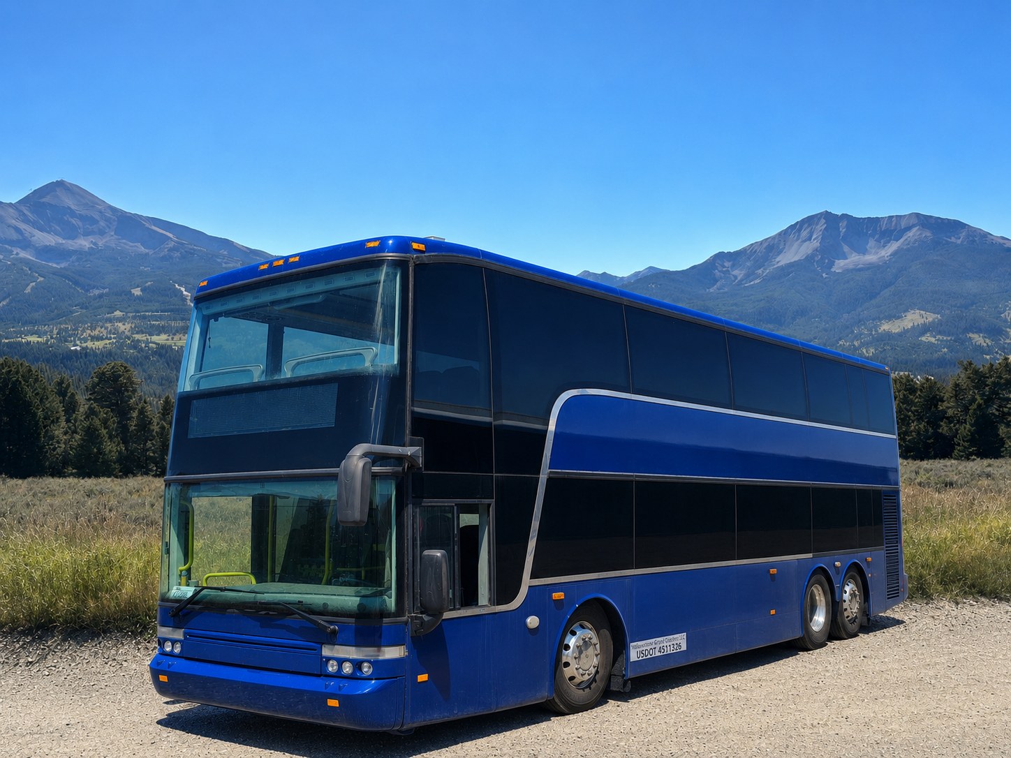 The sapphire-blue double-decker coach beneath the Montana mountains